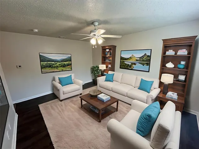 a living room with furniture and a ceiling fan