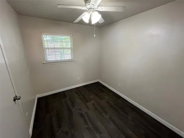 en empty room with wooden floor and fan