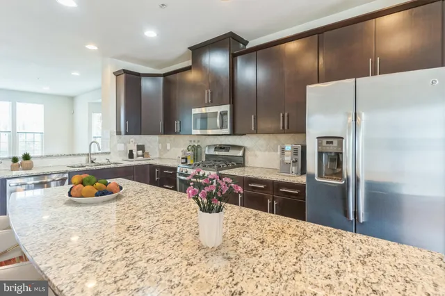 a kitchen with a refrigerator sink and wooden cabinets