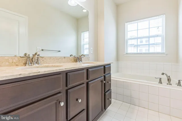 a spacious bathroom with double sink and a bathtub