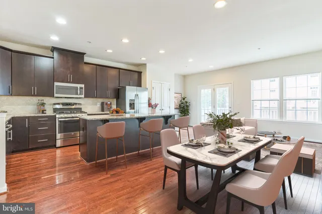 a kitchen with a dining table chairs and refrigerator