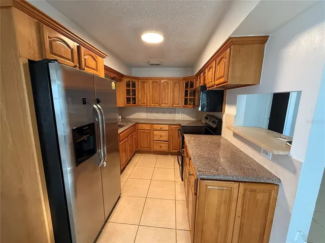 a kitchen with stainless steel appliances granite countertop a refrigerator a stove and a sink