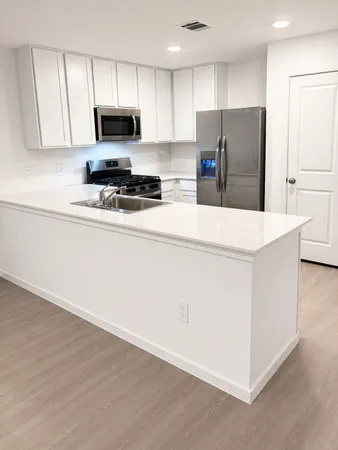 a kitchen with refrigerator and a stove top oven