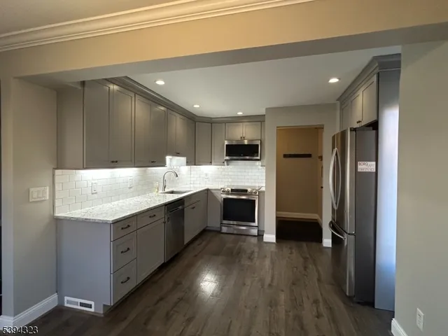 a metallic refrigerator freezer sitting in a kitchen