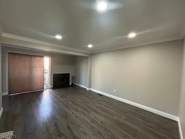 an empty room with wooden floor and fireplace