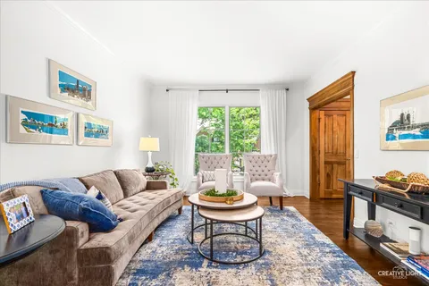 a living room with furniture a table and a large window