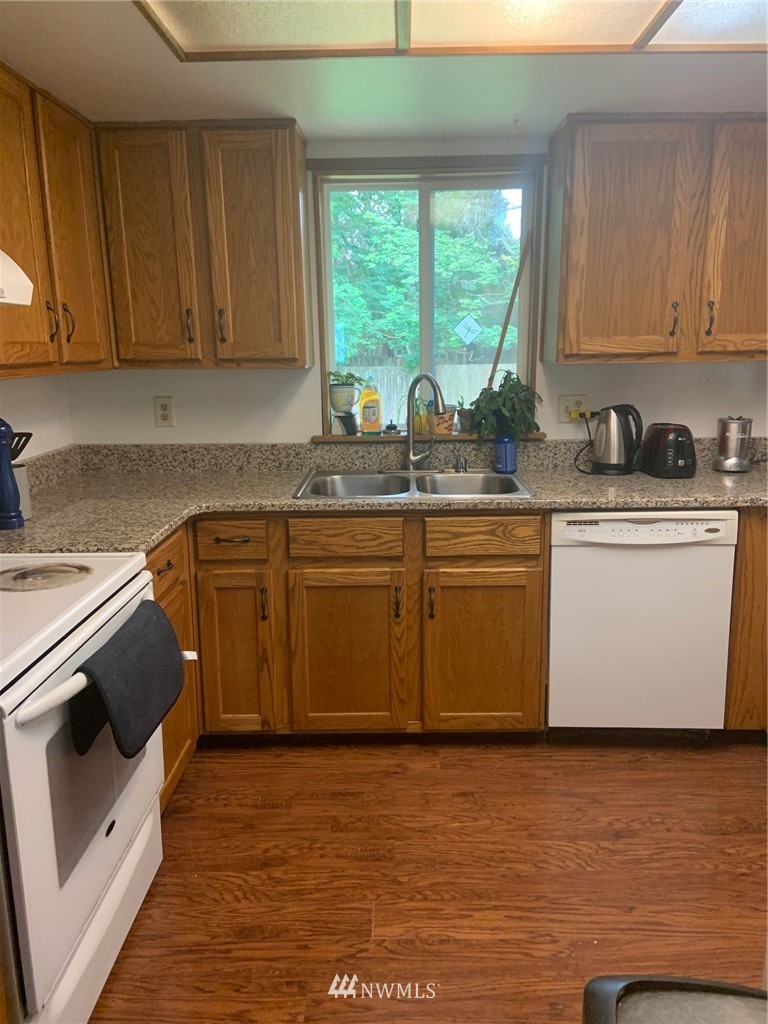 3302 198th Place Southeast Bothell, WA 98012 - Photo 6 of 19 a kitchen with stainless steel appliances granite countertop a stove a sink dishwasher and a microwave oven with cabinets