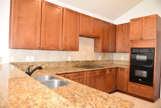 a kitchen with stainless steel appliances granite countertop a sink stove and cabinets
