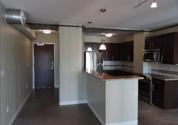 a kitchen with stainless steel appliances kitchen island a refrigerator and a stove top oven