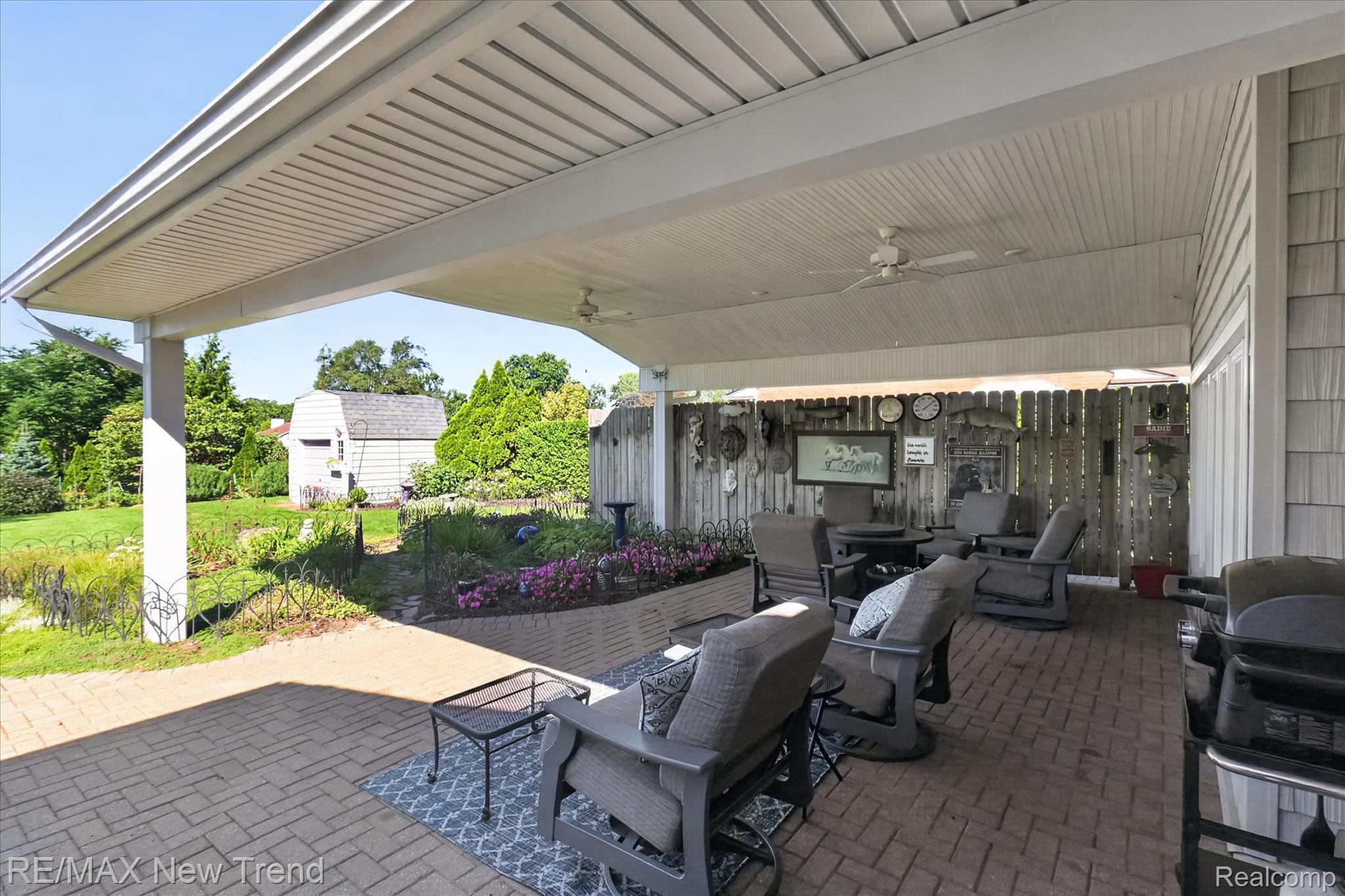 2529 South Commerce Road Walled Lake, MI 48390 - Photo 48 of 66 Expansive covered patio featuring brick pavers, ceiling fans, and a privacy fence