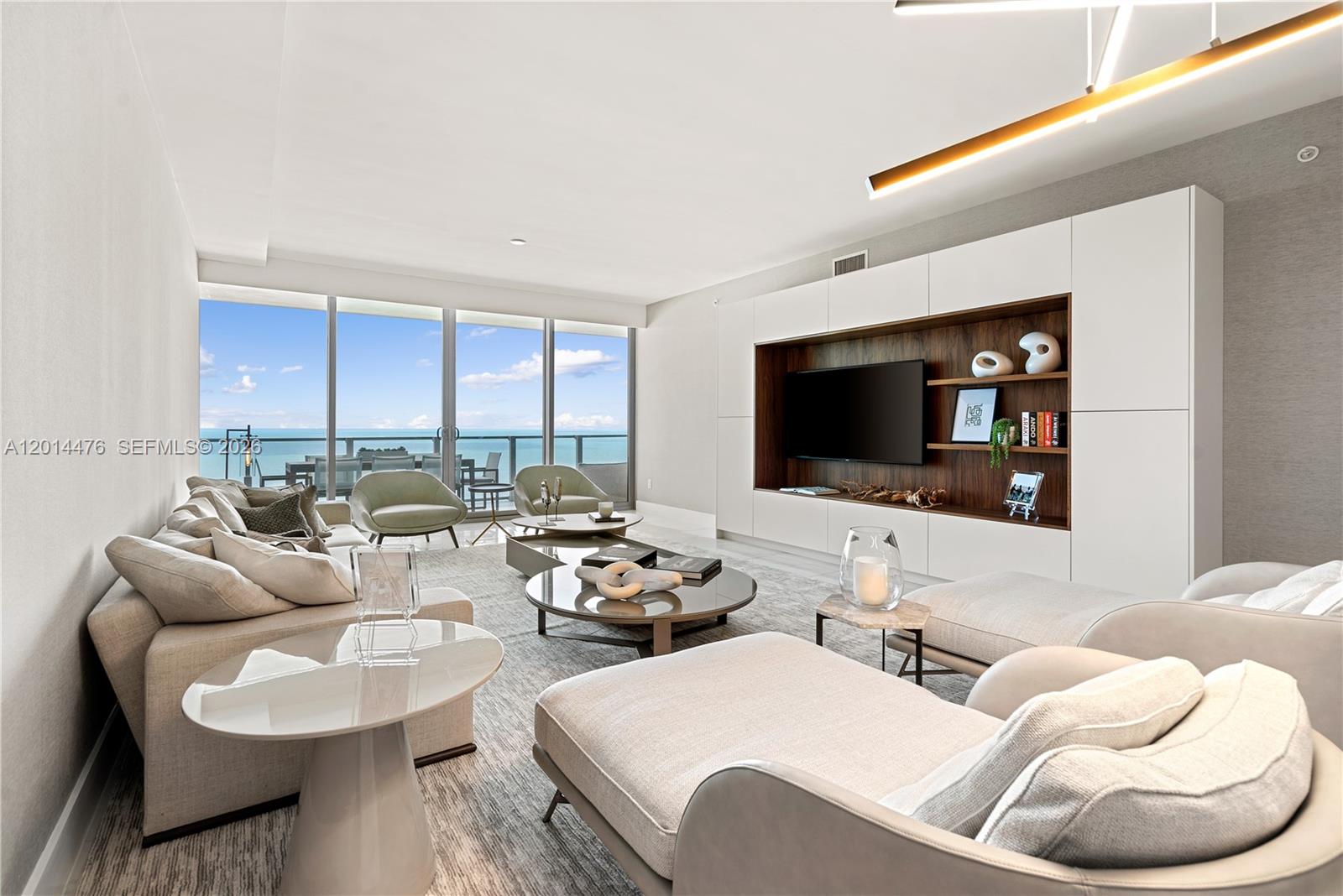 360 Ocean Drive, Unit 1106S Key Biscayne, FL 33149 - Photo 5 of 67 Living Room – A spacious living area showcases floor-to-ceiling glass doors, custom built-ins, and direct views toward the water. Soft neutral furnishings and layered textures create a relaxed, elevated setting for everyday living or entertaining.