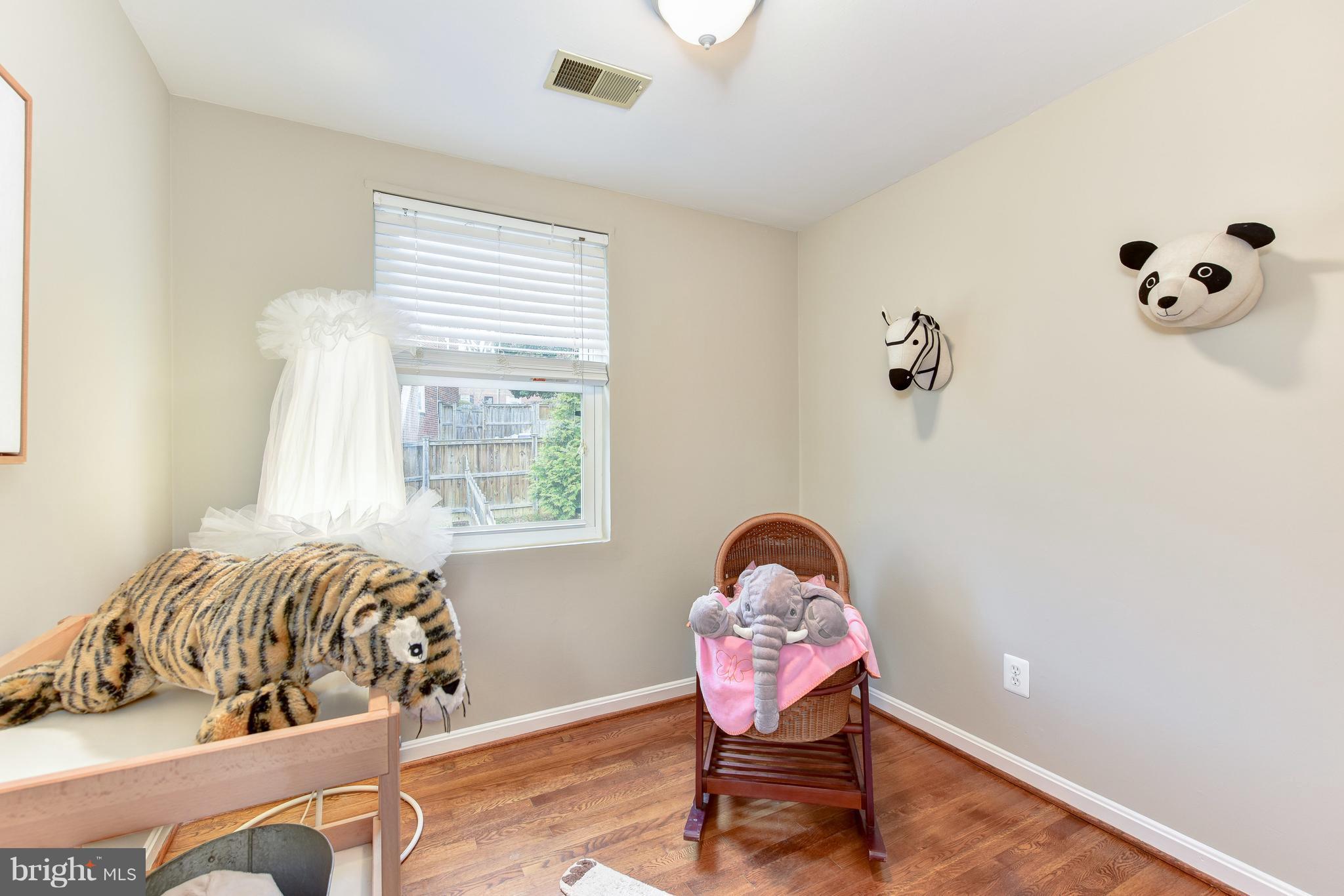 2918 Hickory Street Alexandria, VA 22305 - Photo 16 of 30 a bedroom with a bed and wooden floor