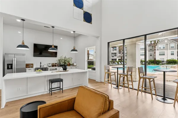 a living room with furniture a flat screen tv and floor to ceiling window