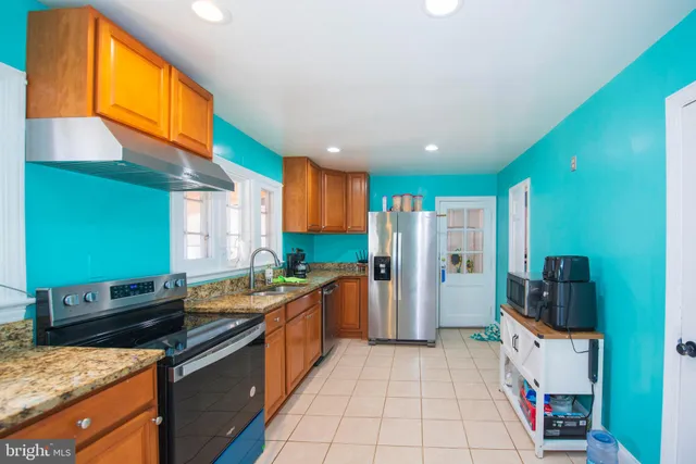 a kitchen with stainless steel appliances granite countertop a stove a sink and a refrigerator