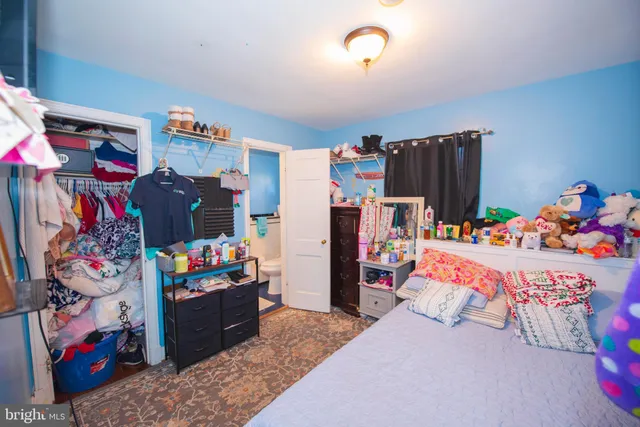 a bedroom with a bed and a dresser in it