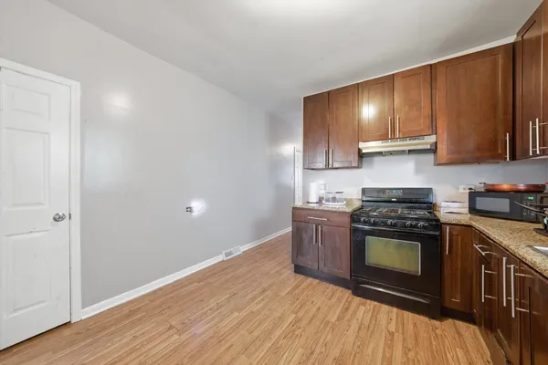a kitchen with granite countertop wooden floors and stainless steel appliances