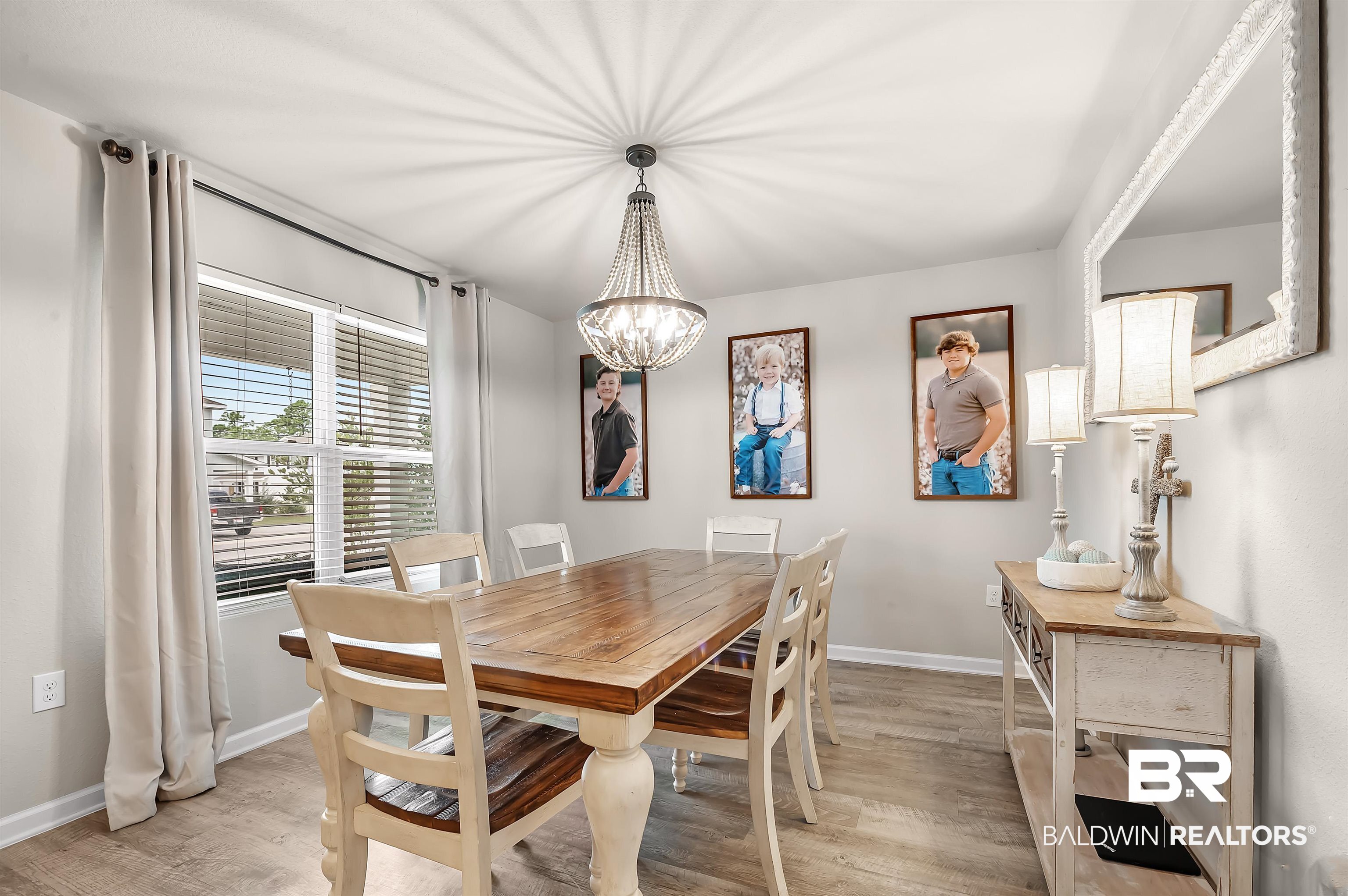 24549 Broken Sound Loop Orange Beach, AL 36561 - Photo 13 of 57 Dining space with a chandelier and light hardwood / wood-style floors