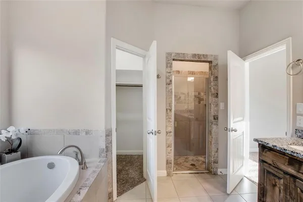 a bathroom with a tub sink shower and mirror