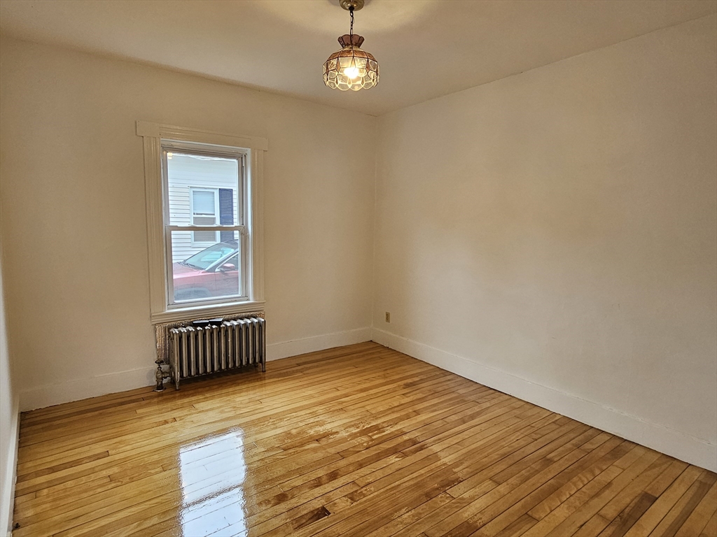 20 Kosta Street, Unit 1 Worcester, MA 01607 - Photo 4 of 17 a view of an empty room with wooden floor and a window