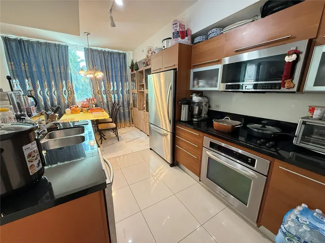 a kitchen with stainless steel appliances a stove microwave and refrigerator