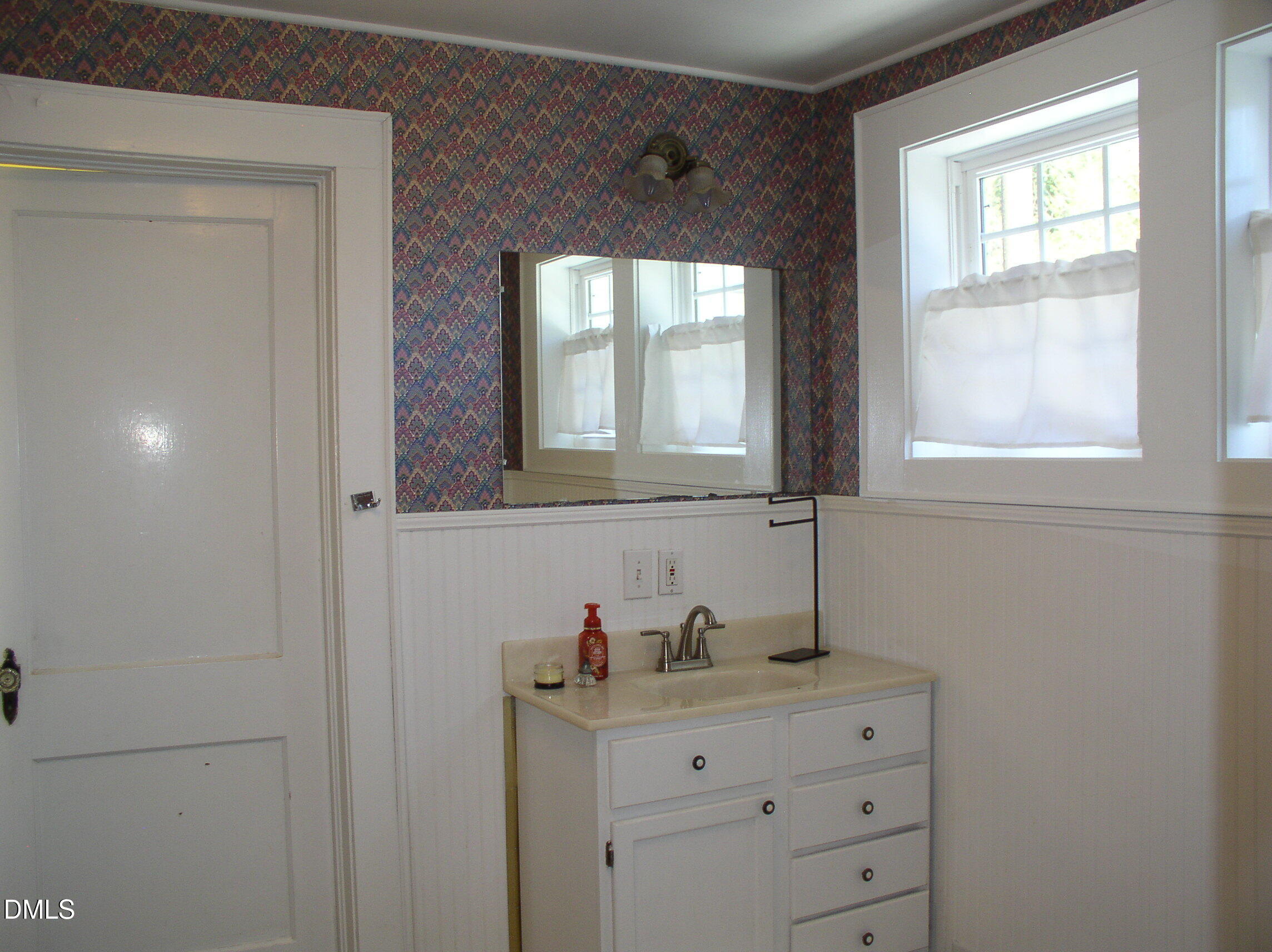 934 South Chestnut Street Henderson, NC 27536 - Photo 25 of 56 a bathroom with a sink and a mirror