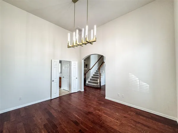 a view of a room with wooden floor staircase and a chandelier