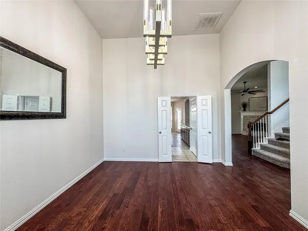 a view of a hallway with wooden floor and a living room