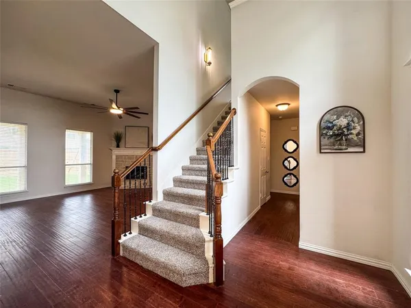 an empty room with a chandelier fan and windows