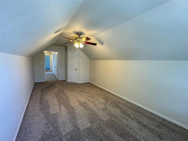 an empty room with a chandelier fan and a chandelier fan