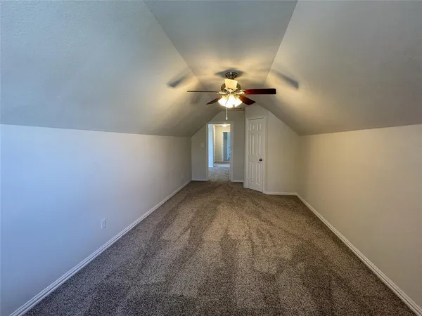 a view of an empty room with a ceiling fan and a window