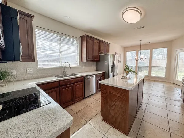 a kitchen with a stove sink and cabinets