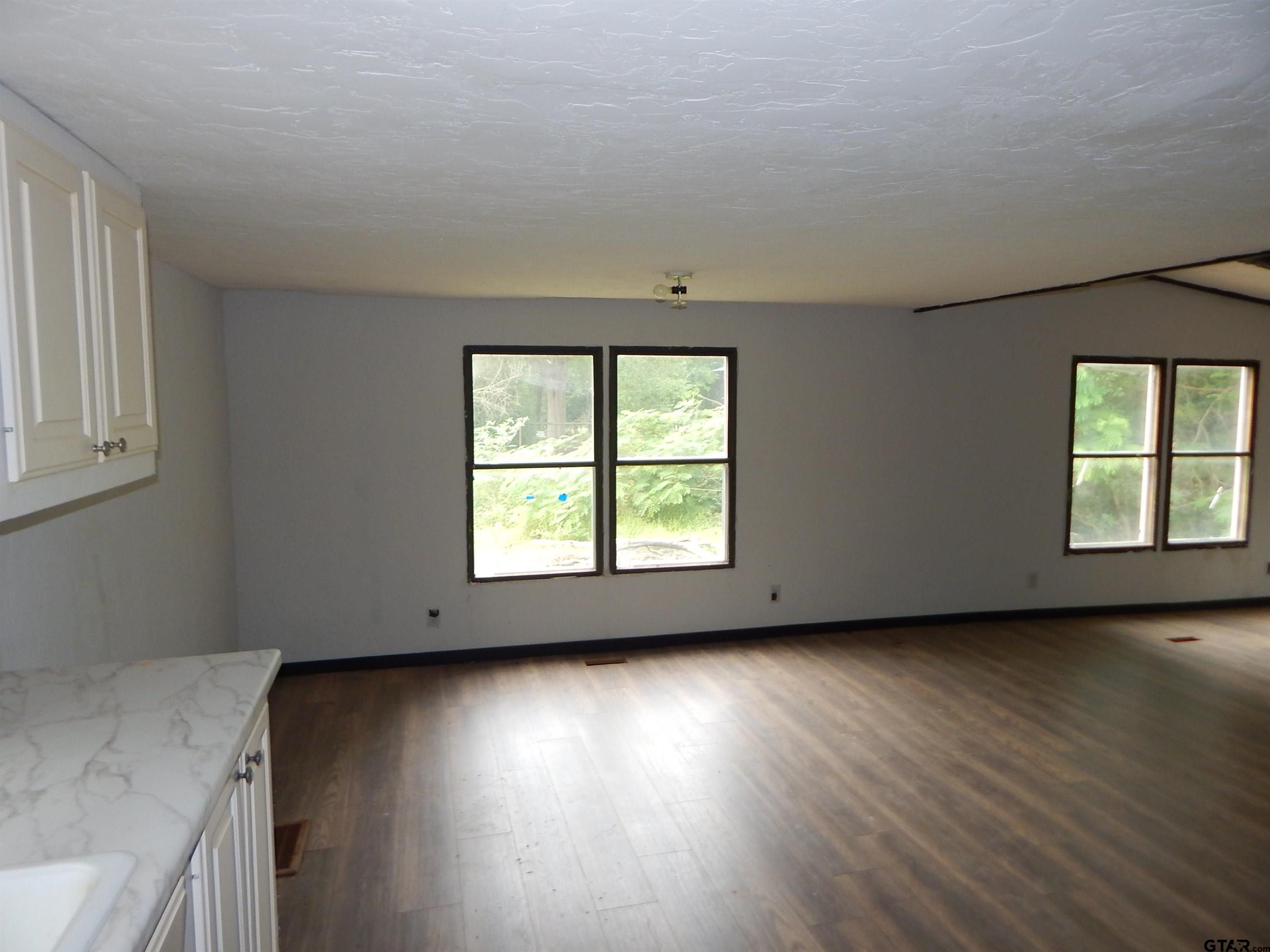 228 Gage Road Big Sandy, TX 75755 - Photo 3 of 13 an empty room with wooden floor and windows