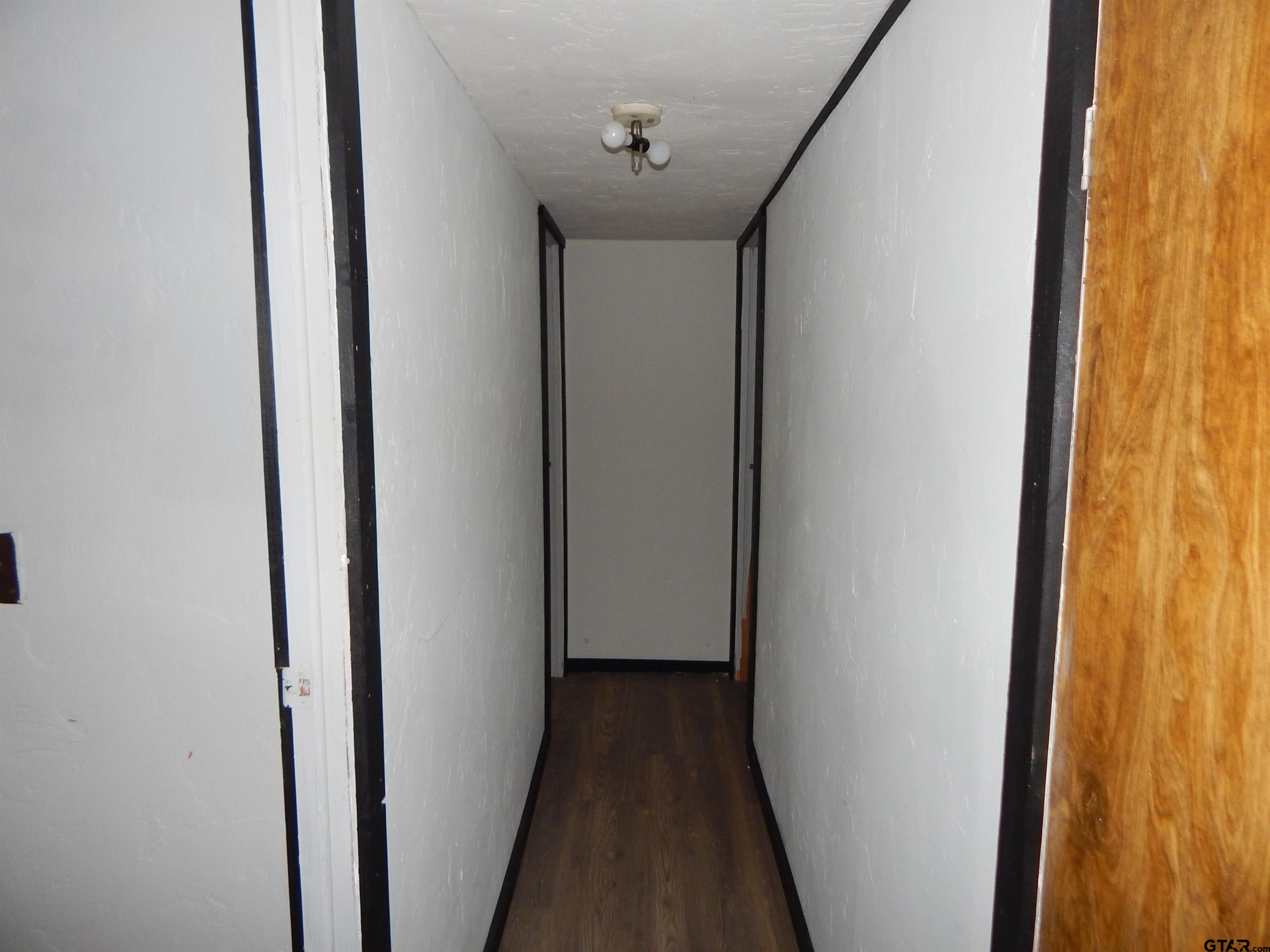 228 Gage Road Big Sandy, TX 75755 - Photo 4 of 13 a view of a hallway with wooden floor and door