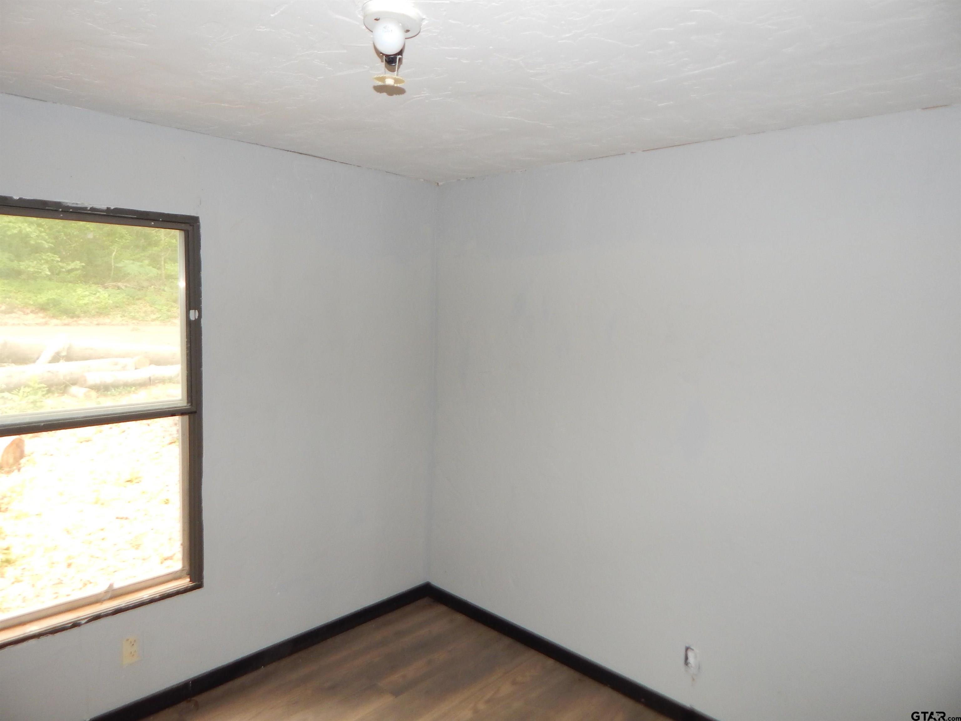 228 Gage Road Big Sandy, TX 75755 - Photo 5 of 13 an empty room with wooden floor and windows