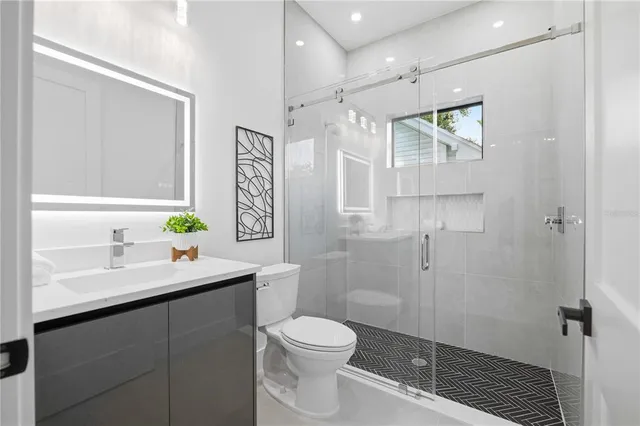 an empty room with wooden floor ceiling fan and windows