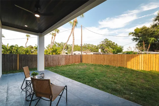 a view of a white house with a big yard and large trees