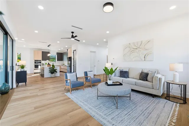 a living room with furniture kitchen view and a chandelier