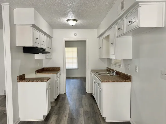a kitchen with a stove sink and cabinets