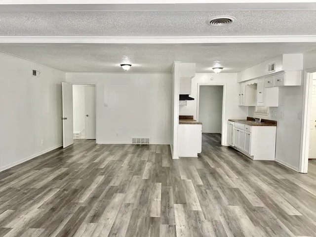 a view of a kitchen with wooden floor and appliances
