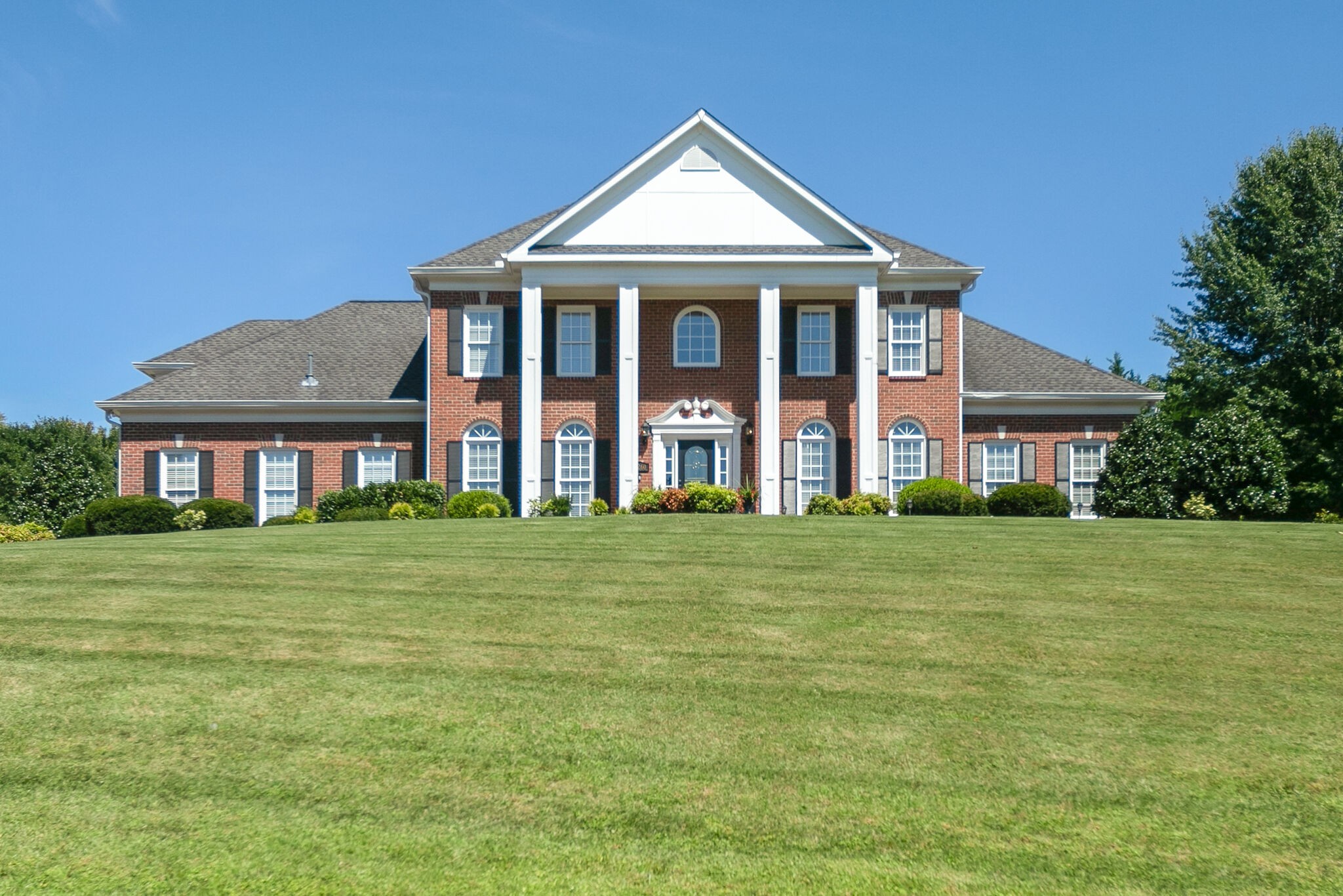 a front view of a house with a garden
