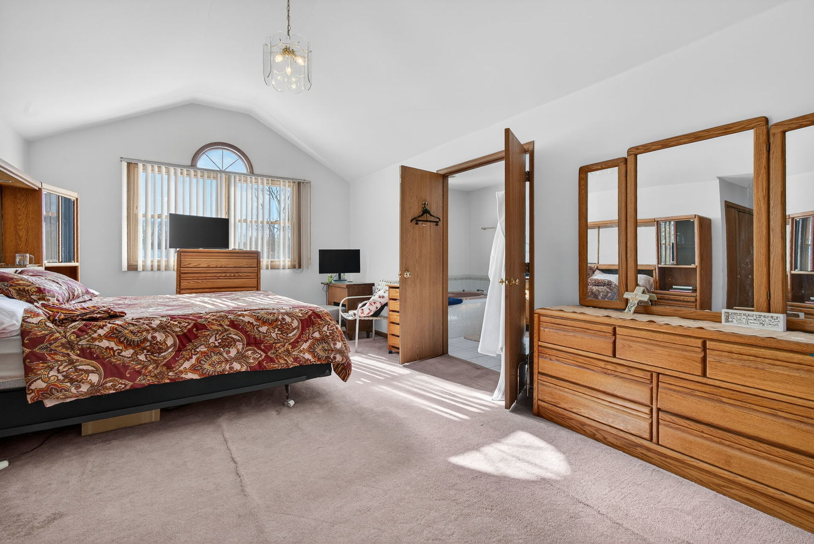 4448 Maple Avenue Matteson, IL 60443 - Photo 18 of 26 a bedroom with a large bed and a chandelier