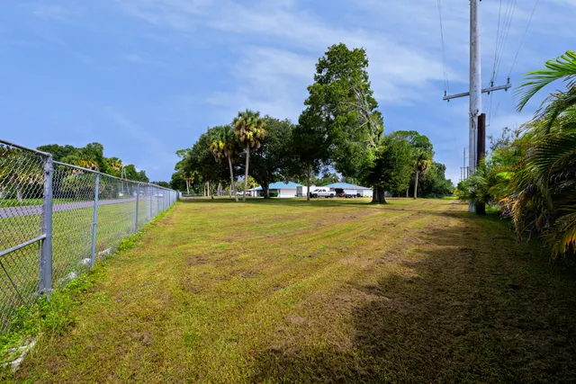 a view of swimming pool with outdoor seating and covered with trees in the background