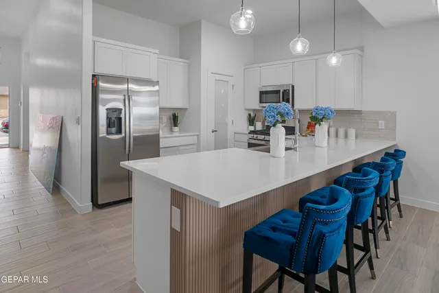 a kitchen with stainless steel appliances kitchen island granite countertop a kitchen island a stove a table and chairs
