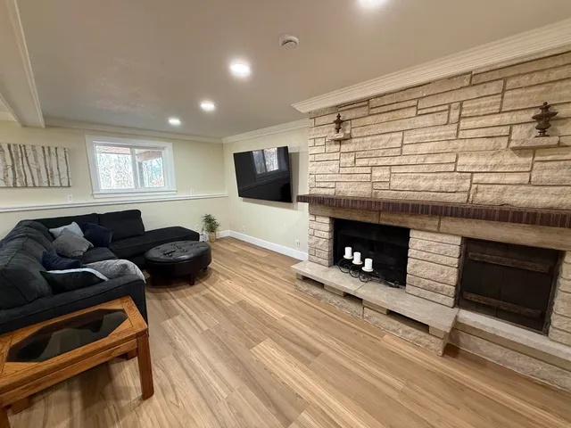 a living room with furniture a flat screen tv and a fireplace