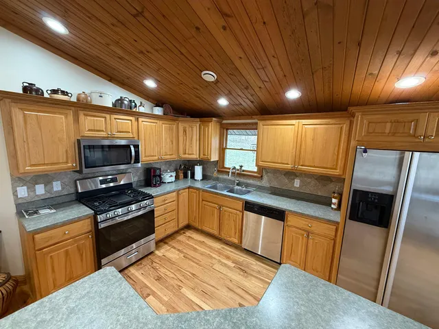 a kitchen with granite countertop stainless steel appliances and wooden cabinets