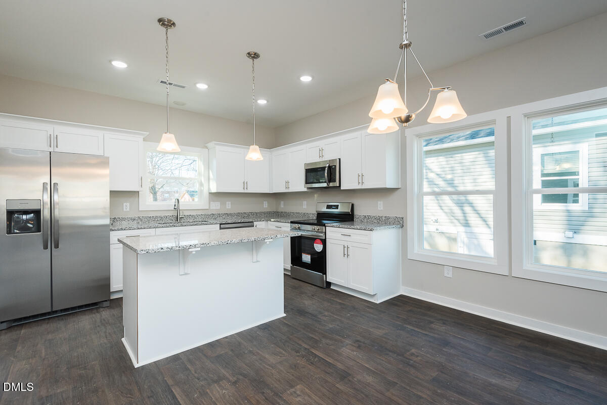 555 Pinnix Road Burlington, NC 27217 - Photo 6 of 21 a kitchen with stainless steel appliances granite countertop a refrigerator a sink dishwasher a stove and white cabinets with wooden floor