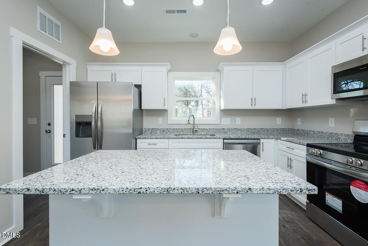555 Pinnix Road Burlington, NC 27217 - Photo 8 of 21 a kitchen with granite countertop a sink a center island stainless steel appliances and cabinets