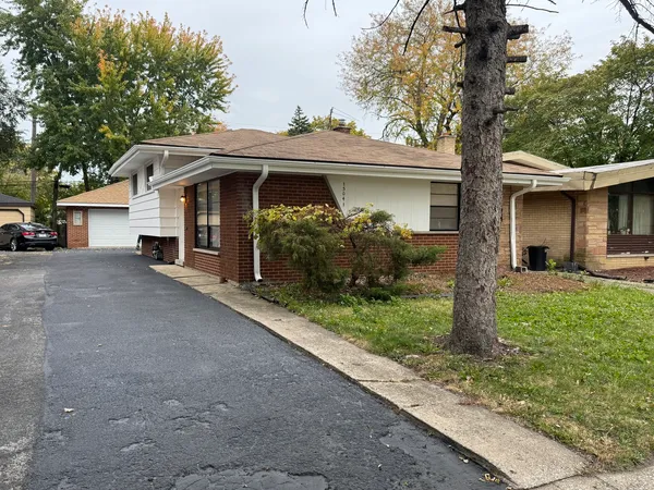 a view of a house with a yard and large tree