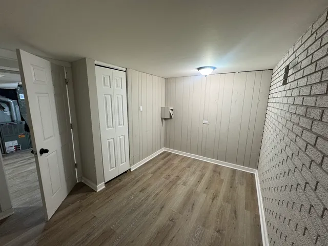 an empty room with wooden floor and a bathroom