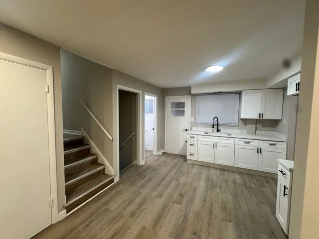 a kitchen with white cabinets and sink
